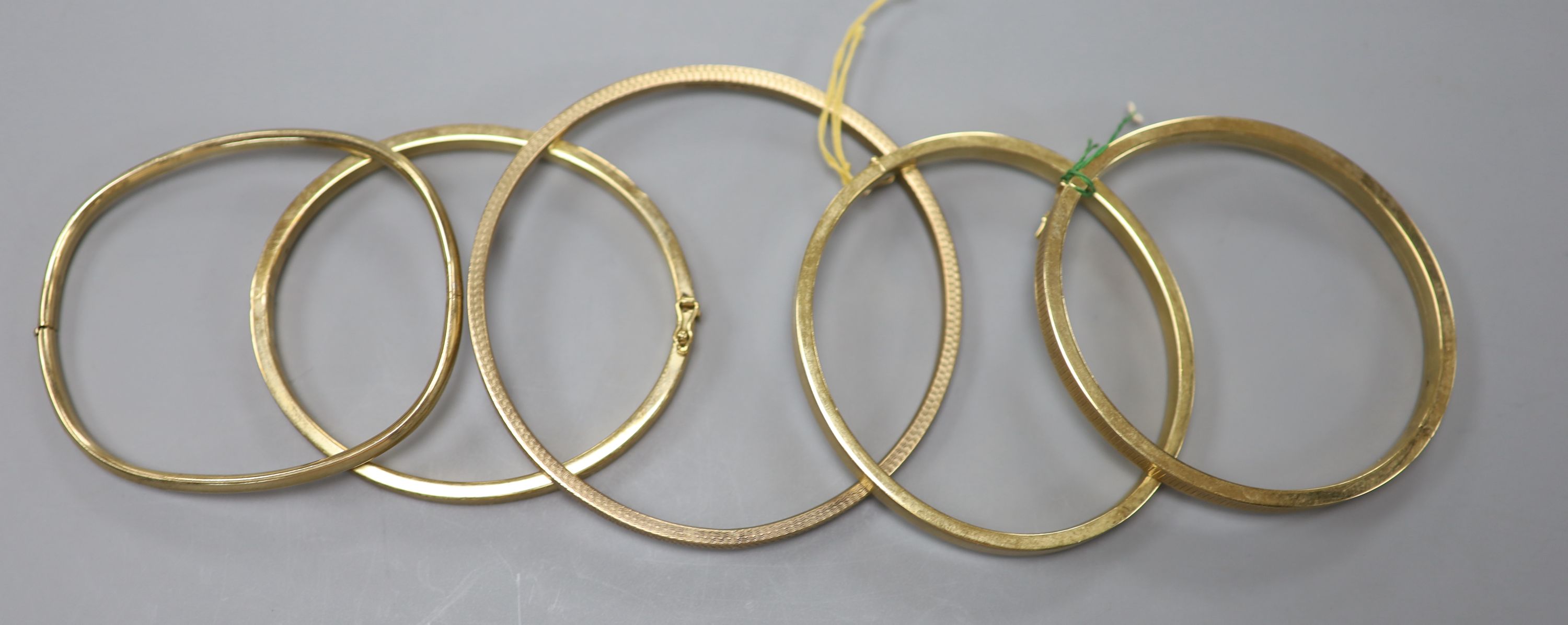 Two modern 9ct gold bangles, one hinged, 33.5 grams and three 9ct gold filled hinged bangles.